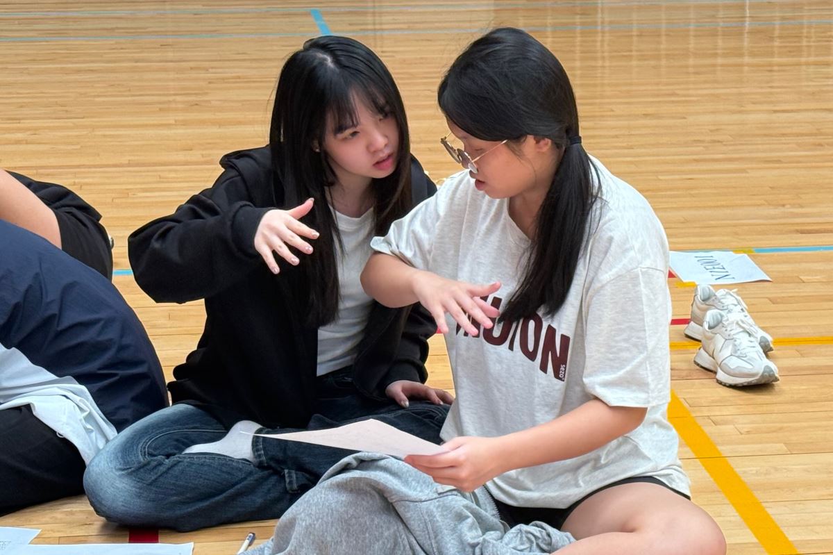 小隊員正在閱讀日記選項中的動作描述，透過實際比劃手勢對照手語圖卡